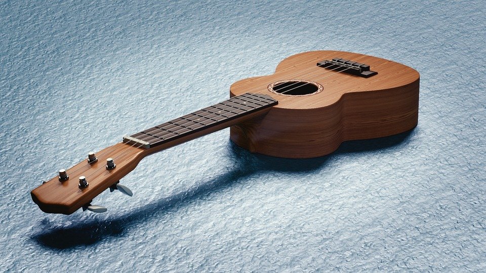 A brown polished ukulele placed on a blue mat