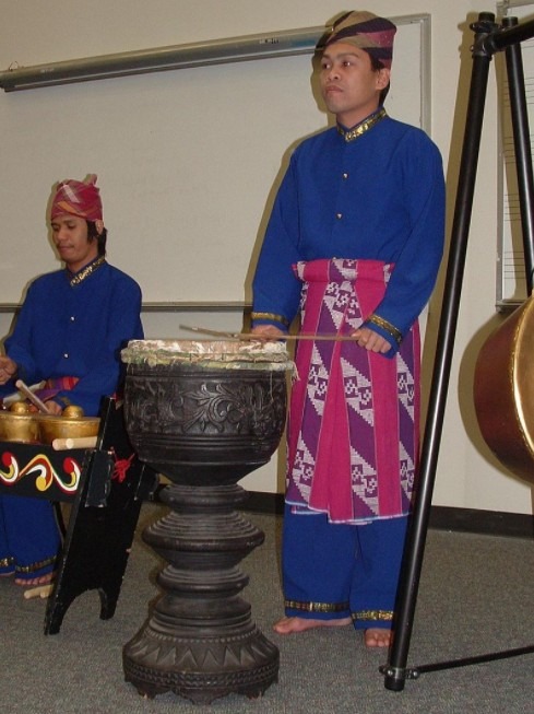 A photo of a man playing the dabakan as part of an ensemble