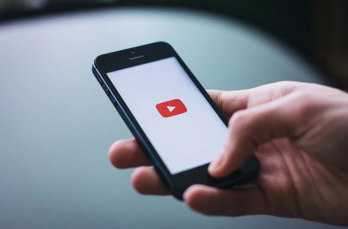 a person holding a smartphone with YouTube opened