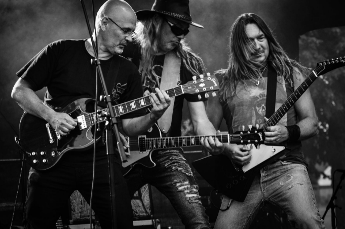 group-of-men-playing-guitar-in-concert-in-grayscale-photo