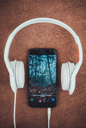 turned-on-black-samsung-smartphone-between-headphones